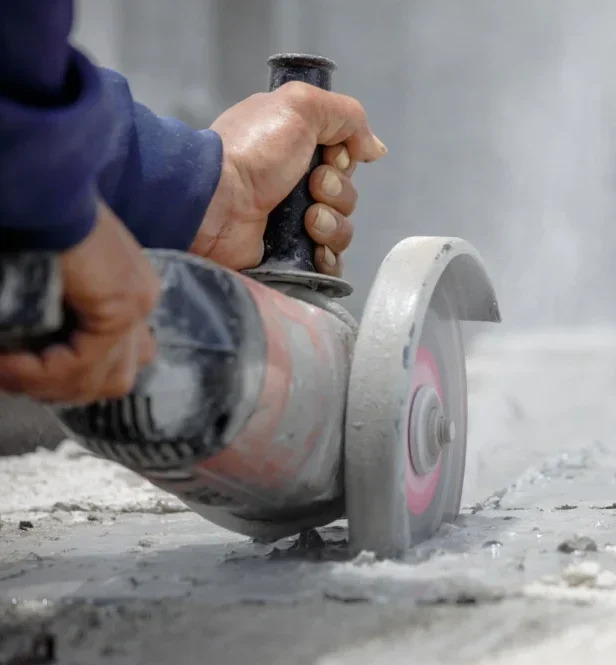 Worker using tool cut concrete floor - Concrete repair service in Michigan